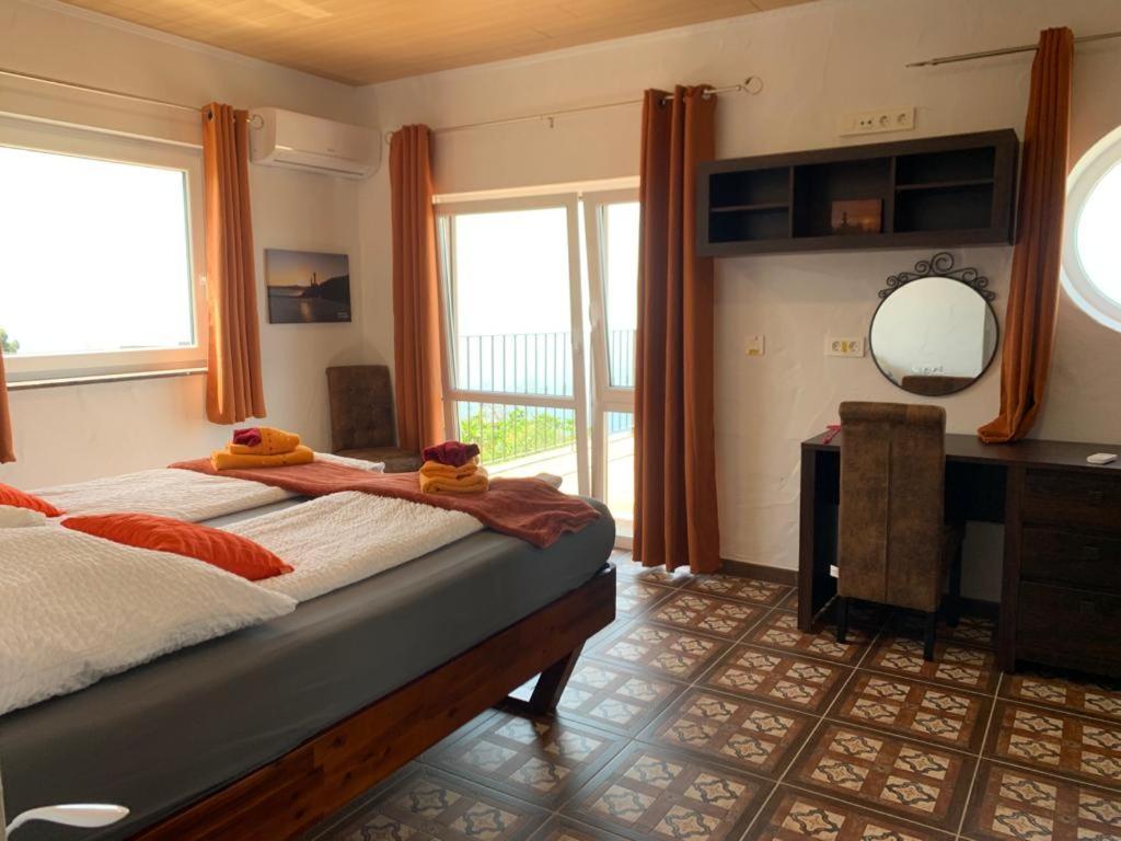 1 dormitorio con cama, escritorio y espejo en HRlos Piratas - Ferien Haus La Palma - GOOD WLAN !!, en Tijarafe