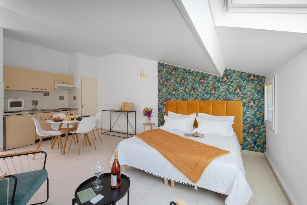 a bedroom with a large bed and a kitchen at Hôtel & Résidence San Roccu in Saint-Florent