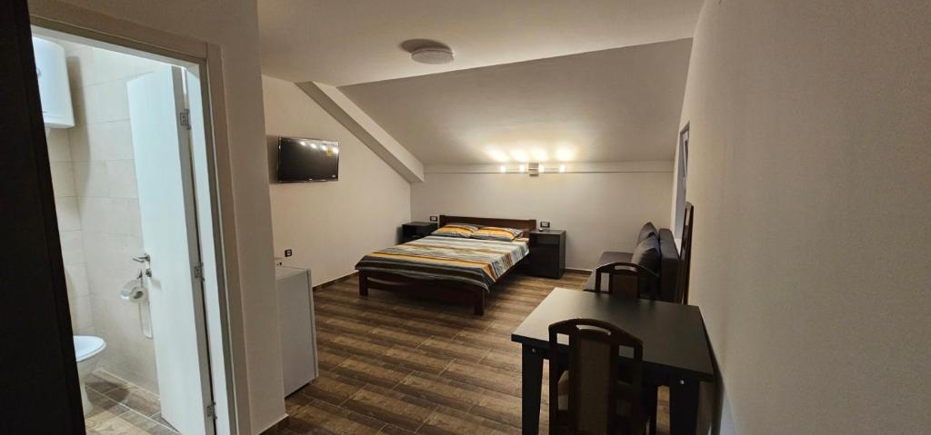 een slaapkamer met een bed en een tafel in een kamer bij Apartmani Kovačević Banja Vrujci in Gunjica