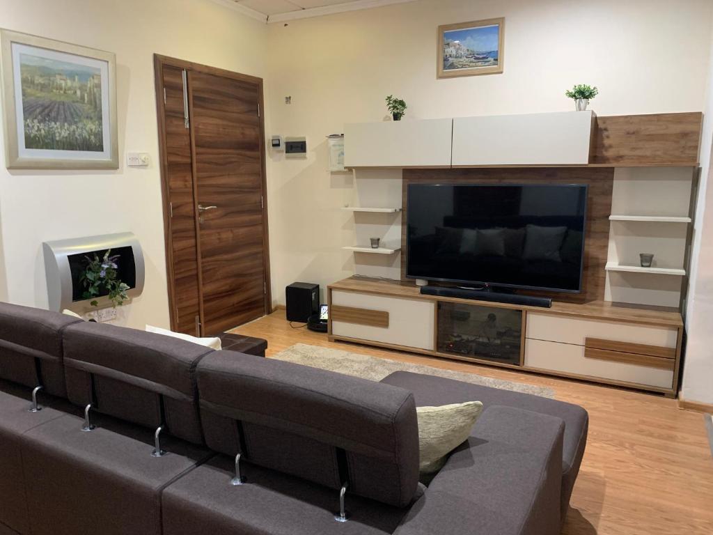 a living room with a couch and a flat screen tv at Caris Gem in Birżebbuġa