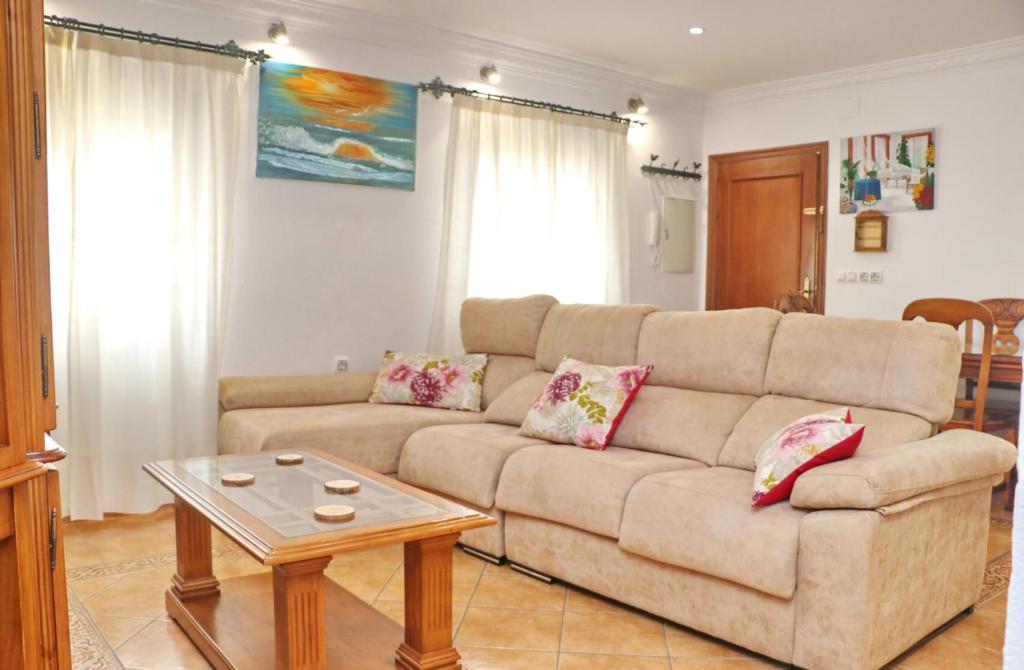 een woonkamer met een bank en een tafel bij Apartamento Acuario in Conil de la Frontera