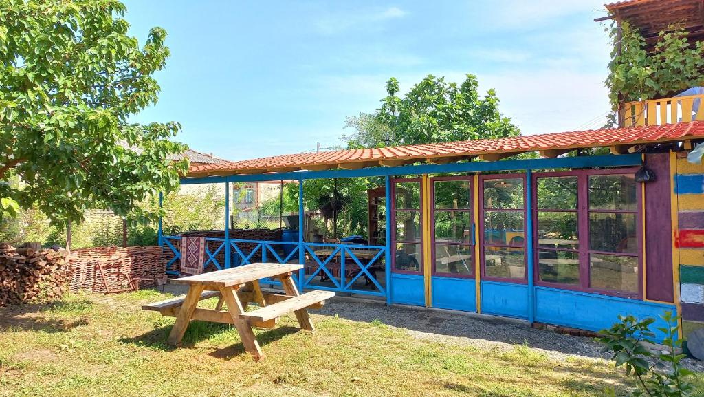 Veli Guest House • საოჯახო სასტუმრო ველი في Zemo Alvani: كرسي نزهة خشبي أمام مبنى
