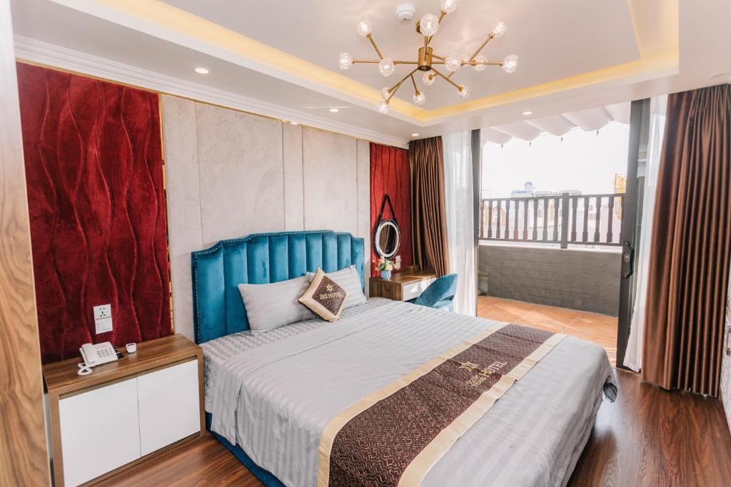 Un dormitorio con una cama azul y una lámpara de araña. en Tâm Thắng Hotel, en Ha Long