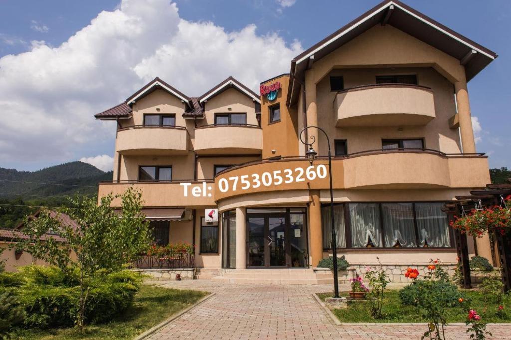 a building with a sign on the front of it at Pensiunea Roua in Piatra Neamţ