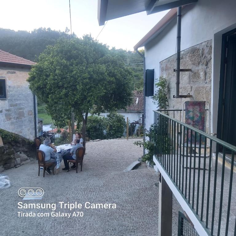 un gruppo di persone seduti a un tavolo su un patio di Casa do Mateus a Santa Leocádia
