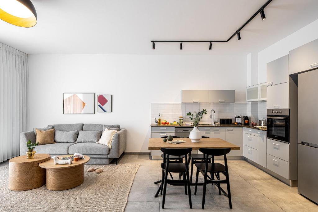 a kitchen and living room with a couch and a table at Mate ALLENBY - By HOMY in Tel Aviv