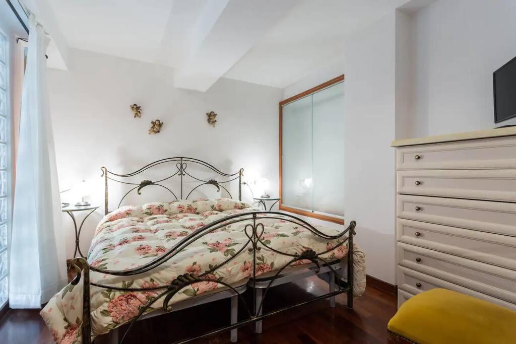 um quarto com uma cama com uma colcha floral e uma cómoda em La belle époque di Assisi 1 em Assis