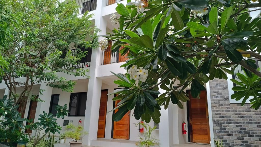 un edificio blanco con árboles delante de él en The Palines Apartment and Guesthouse - Vista Alabang en Manila