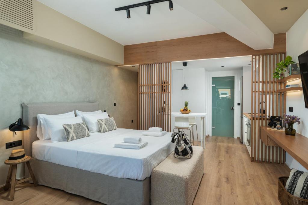 Un dormitorio con una gran cama blanca y una mesa en Nomas lifestyle living, en La Canea