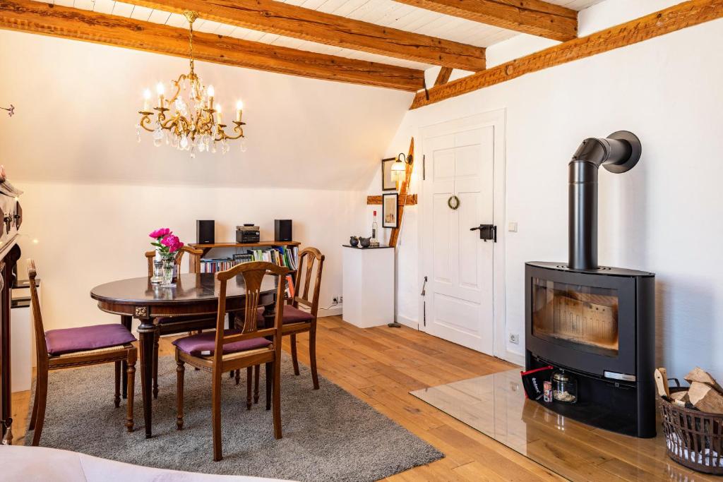 ein Wohnzimmer mit einem Tisch und einem Holzofen in der Unterkunft Kleiner Hof Rosenrot in Königschaffhausen