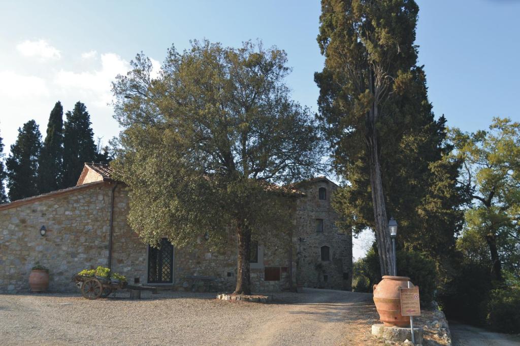 グレーヴェ・イン・キアンティにあるTenuta Poggio ai Mandorliの木の前の古い石造建築