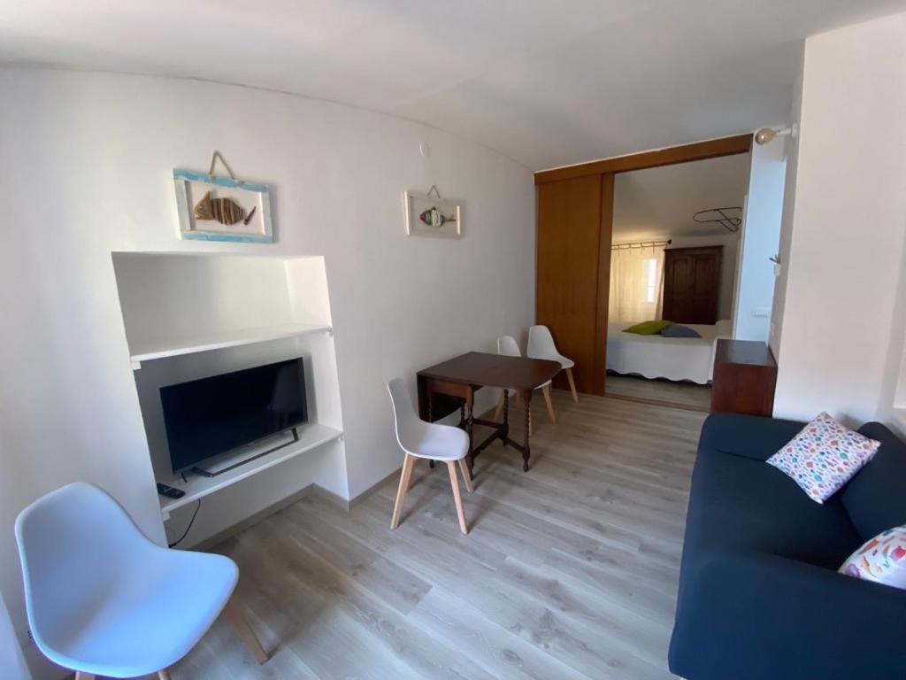 un soggiorno con divano, TV e tavolo di La Casetta a Lerici