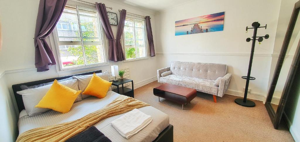 a bedroom with a bed with yellow pillows and a chair at Trendy 2Bed flat Bethnal Green in London