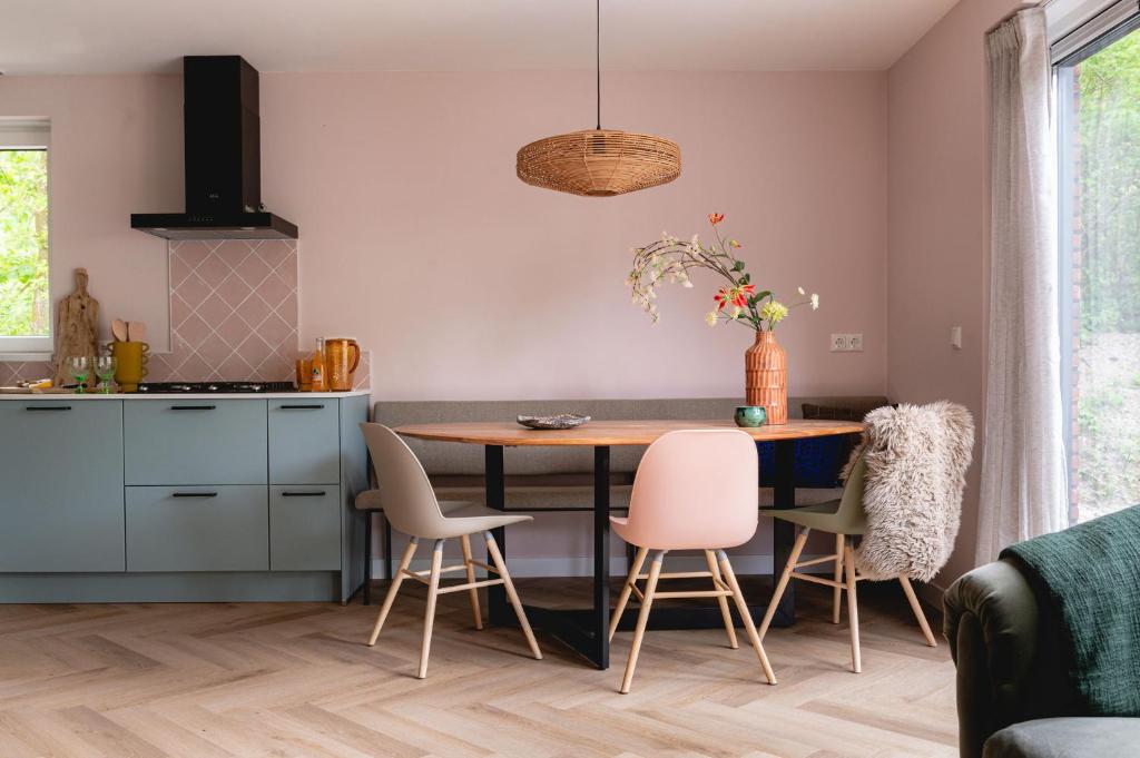eine Küche mit einem Esstisch und Stühlen in der Unterkunft Luxe Vakantiehuis Huismus Veluwe in Nunspeet