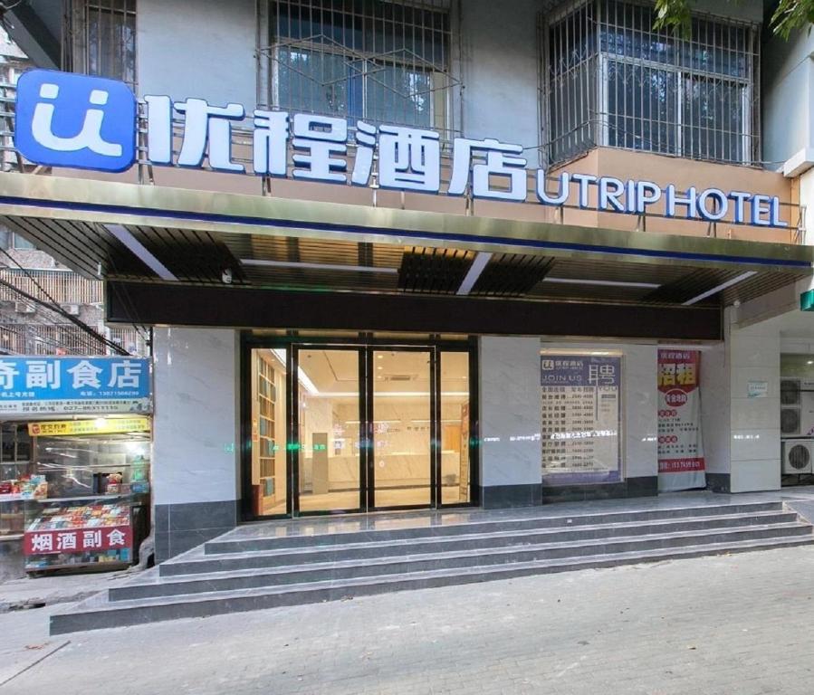 uma loja na frente de um edifício com um sinal nele em Unitour Hotel, Jianghan Road Xiehe Hospital em Wuhan