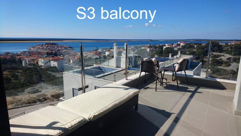 balcón con 2 sillas y vistas al océano en Apartment Summerhill, en Primošten