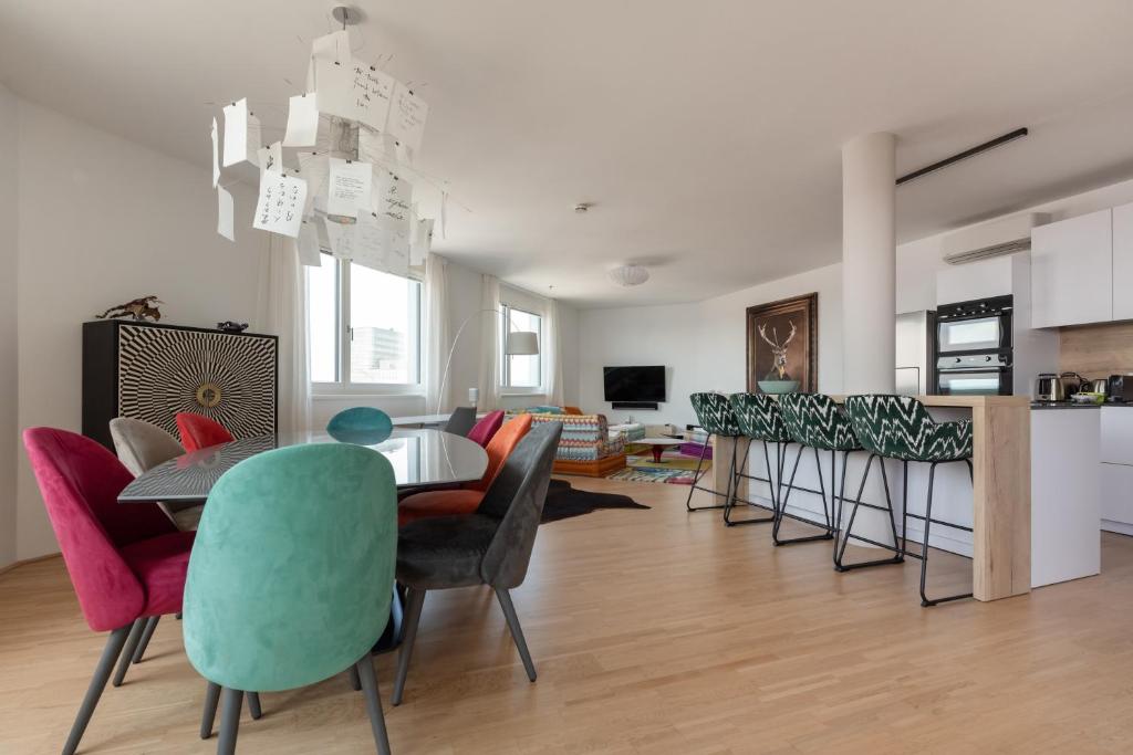uma sala de estar com mesa e cadeiras em Luxus über den Wolken, 18. Stock mit Klimaanlage und Garage em Viena