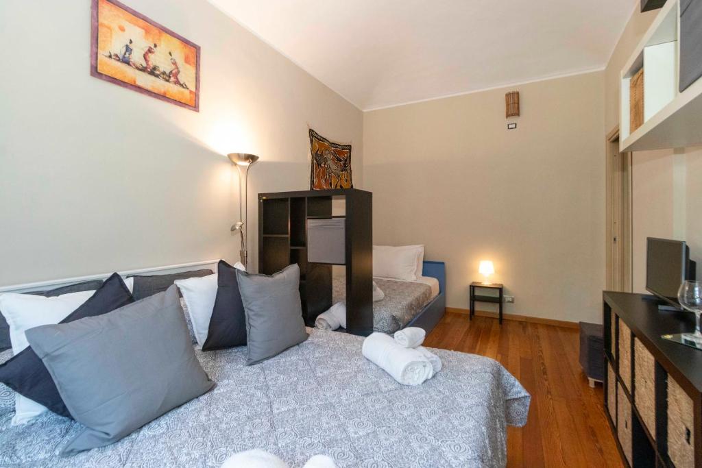 a bedroom with a bed with pillows and a television at Exploring Turin: Crocetta Mini Flat in Turin