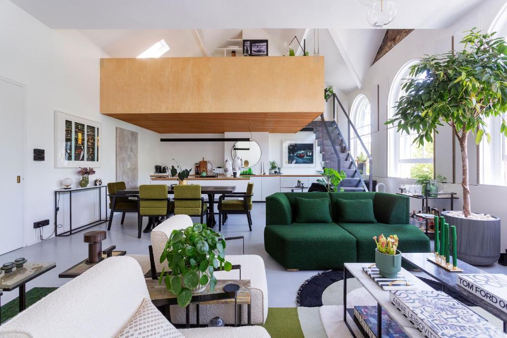 a living room with a green couch and a table at Veeve - Brazilian Trailblazer in London