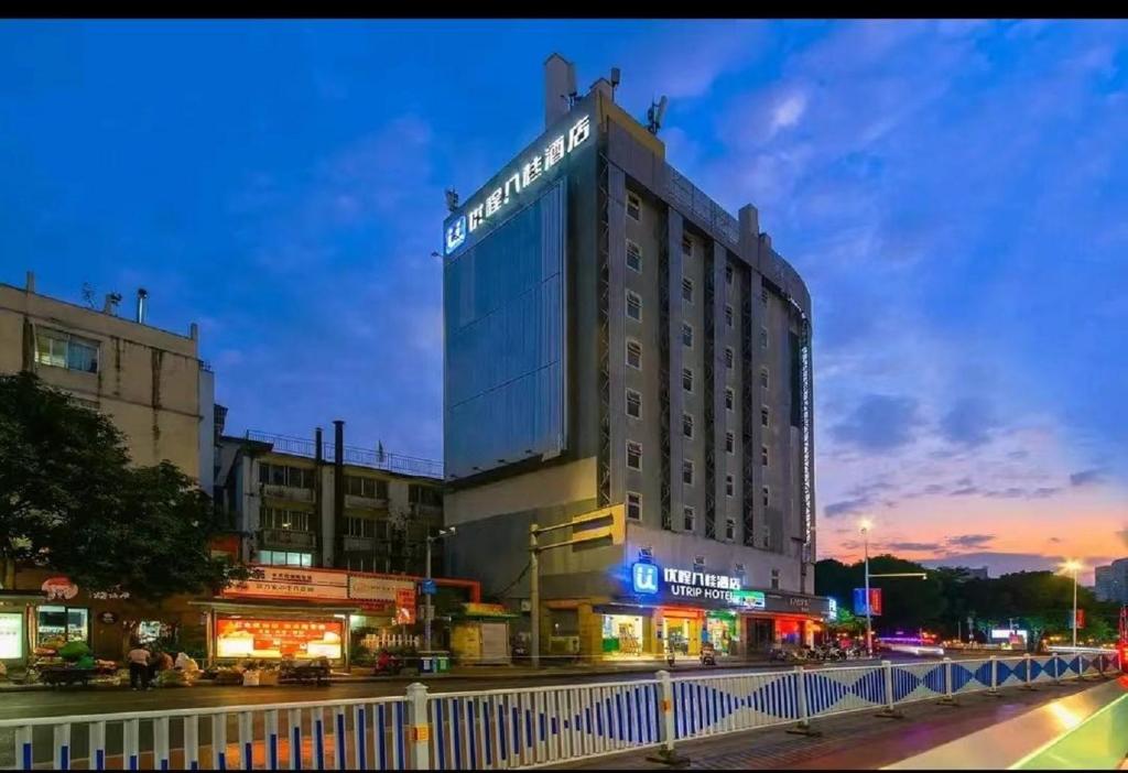 un edificio alto en una calle de la ciudad por la noche en Unitour Hotel, Nanning Chaoyang Plaza Metro Station Sanjieliangxiang, en Nanning