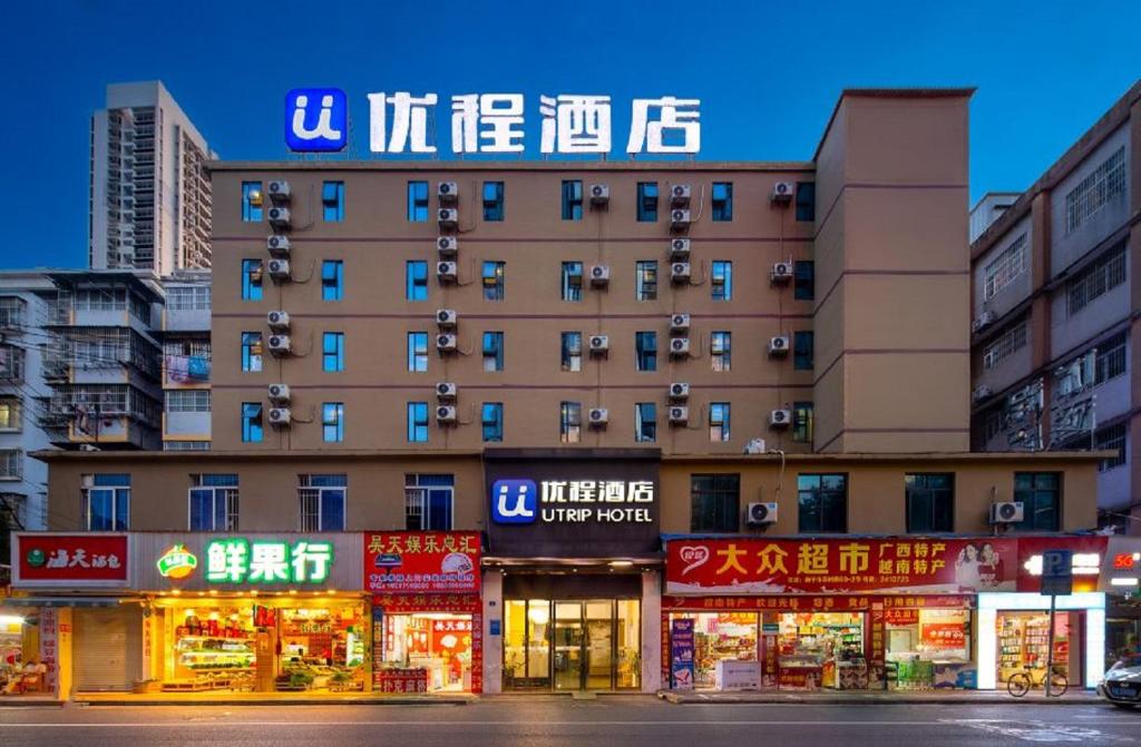 un edificio con letreros en el costado en Unitour Hotel, Nanning Railway Station, en Nanning