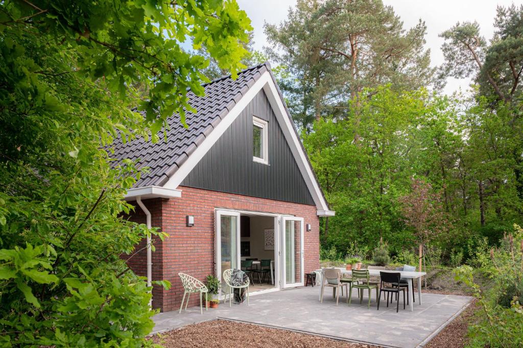 Cette petite maison en briques rouges dispose d'une terrasse. dans l'établissement Luxe Vakantiehuis Ruwe Iep Veluwe, à Nunspeet