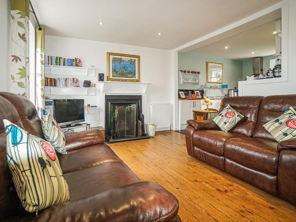 uma sala de estar com mobiliário de couro e uma lareira em The Rennie Mackintosh Retreat em Comrie