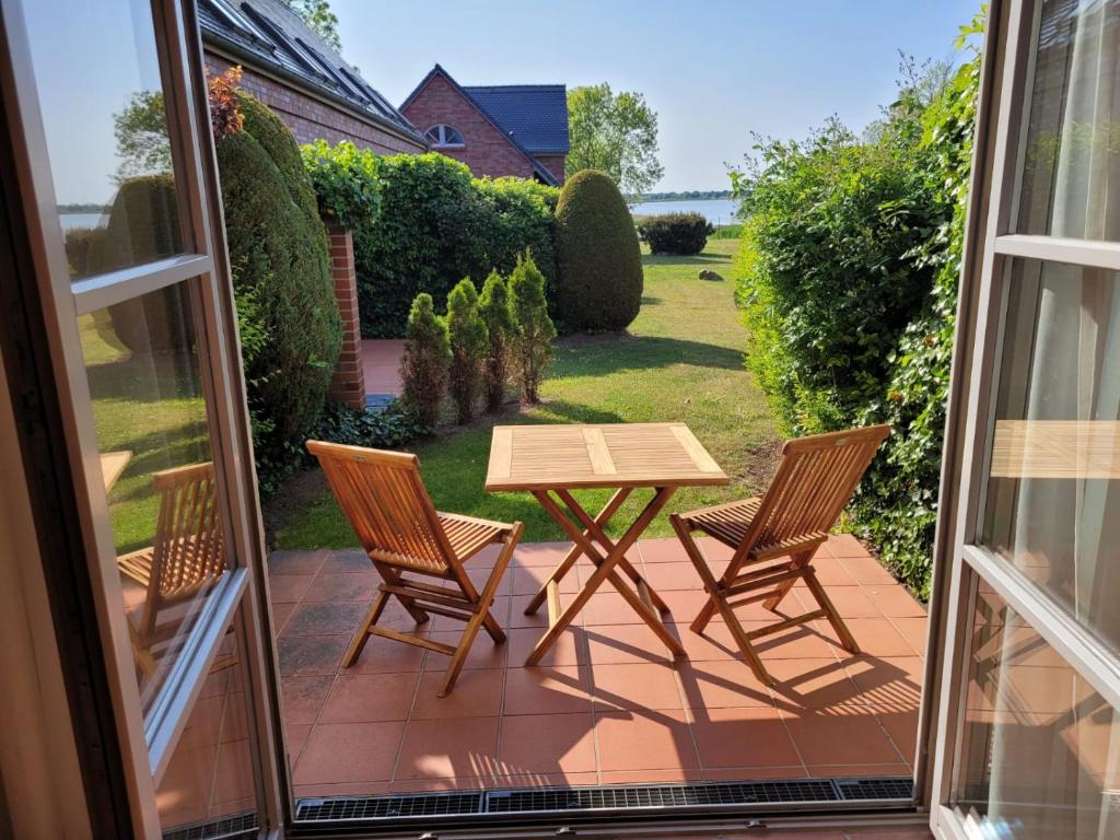 un patio con mesa y sillas en un porche en Ferienwohnung Abendstimmung mit Terrasse, en Dewichow