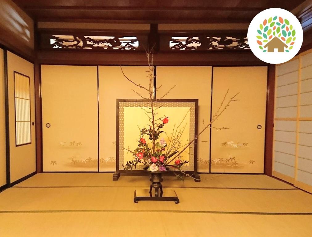 高島市的住宿－Farm stay inn Sanzaemon-tei 母屋GuestHouse Shiga-Takasima Traditional Japanese architecture house，花瓶里放着鲜花的房间