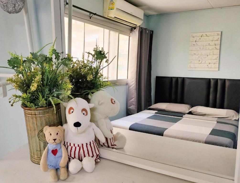 twee teddyberen op de vloer in een slaapkamer bij Nesto Condo at Muangthong in Pak Kret