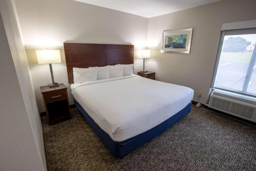 a hotel room with a bed and two lamps and a window at Best Western Plus Lafayette Vermilion River Inn & Suites in Lafayette