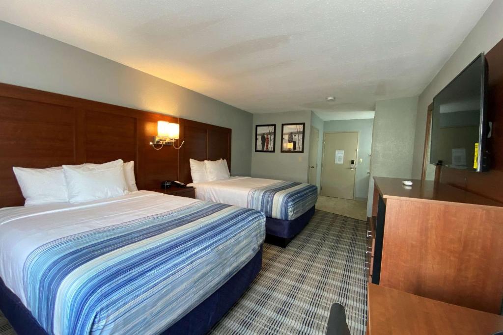 a hotel room with two beds and a television at AmericInn by Wyndham Williamsburg in Williamsburg