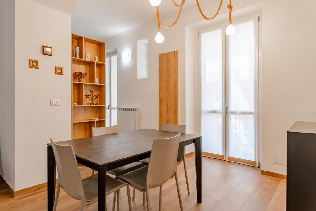 a dining room with a black table and chairs at Royal Apartment by Toh Solution in Turin
