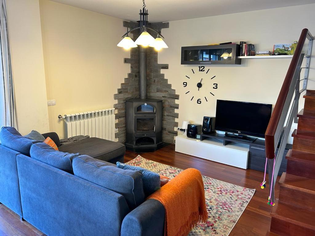 a living room with a blue couch and a fireplace at Apartamento Cosy. Bonito y Acogedor Duplex in Latas