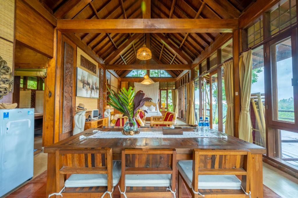 ein Esszimmer mit einem großen Holztisch und Stühlen in der Unterkunft Sang Tirta Resort in Penebel