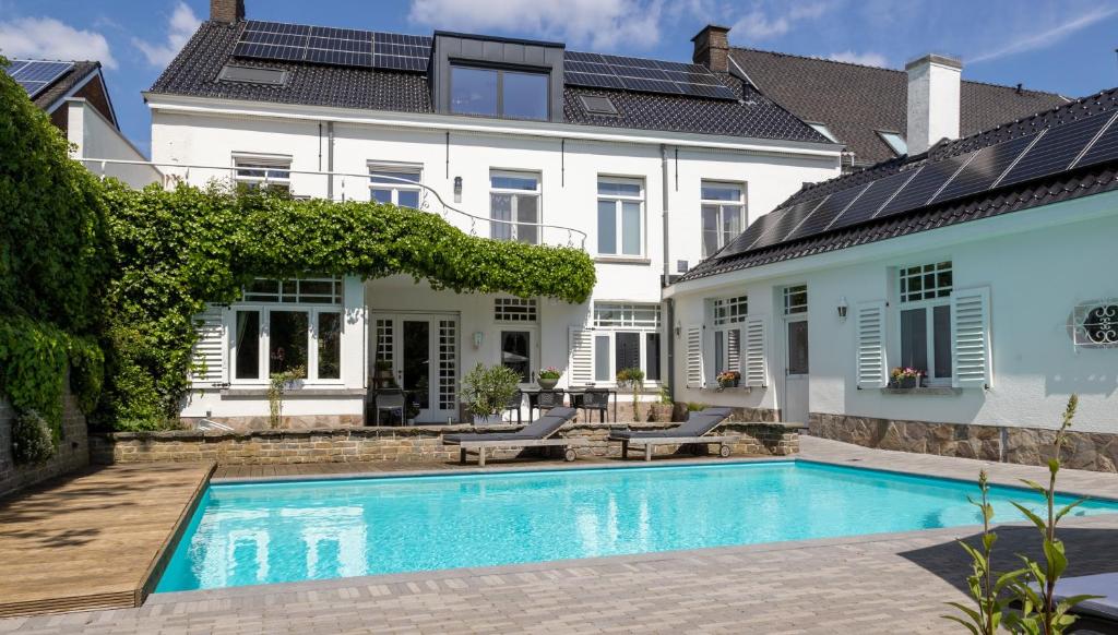 a swimming pool in front of a house at B&B Tannerie in Balen