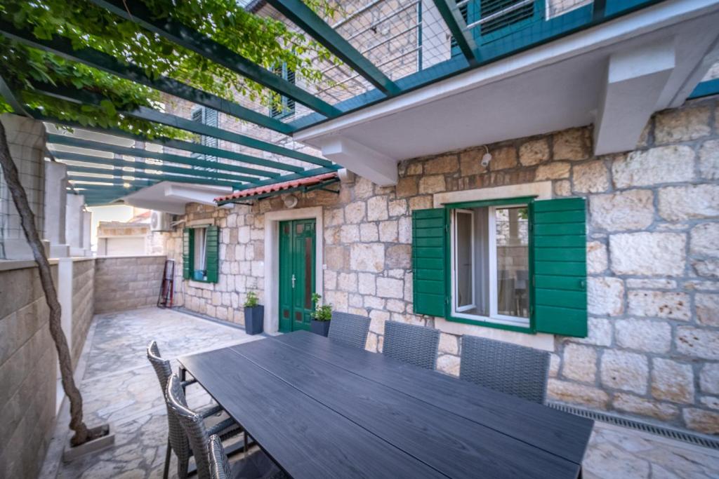 a patio with a wooden table and chairs at Spacious apartment 50 m from the beach in Postira