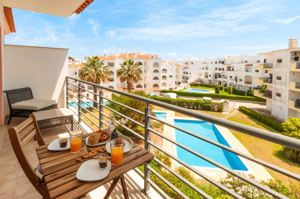 balcone con tavolo e vista sulla piscina di Almond Apartment by OCvillas ad Albufeira