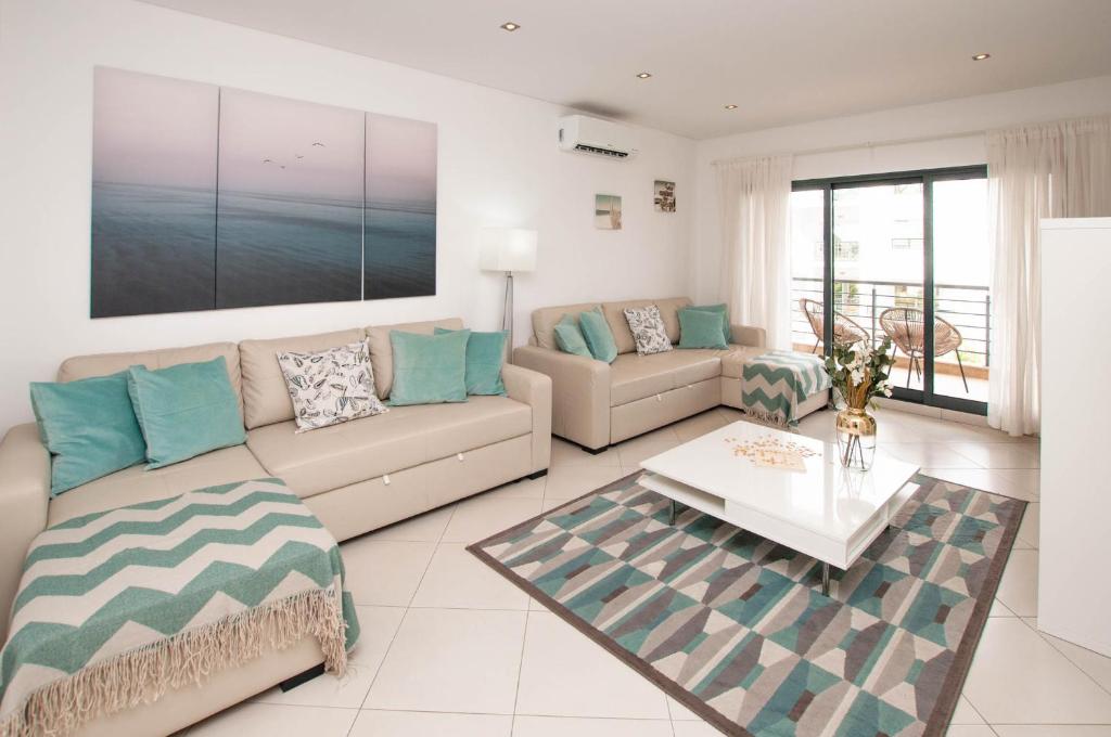 uma sala de estar com um sofá e uma mesa em Almond Apartment by OCvillas em Vale de Pedras