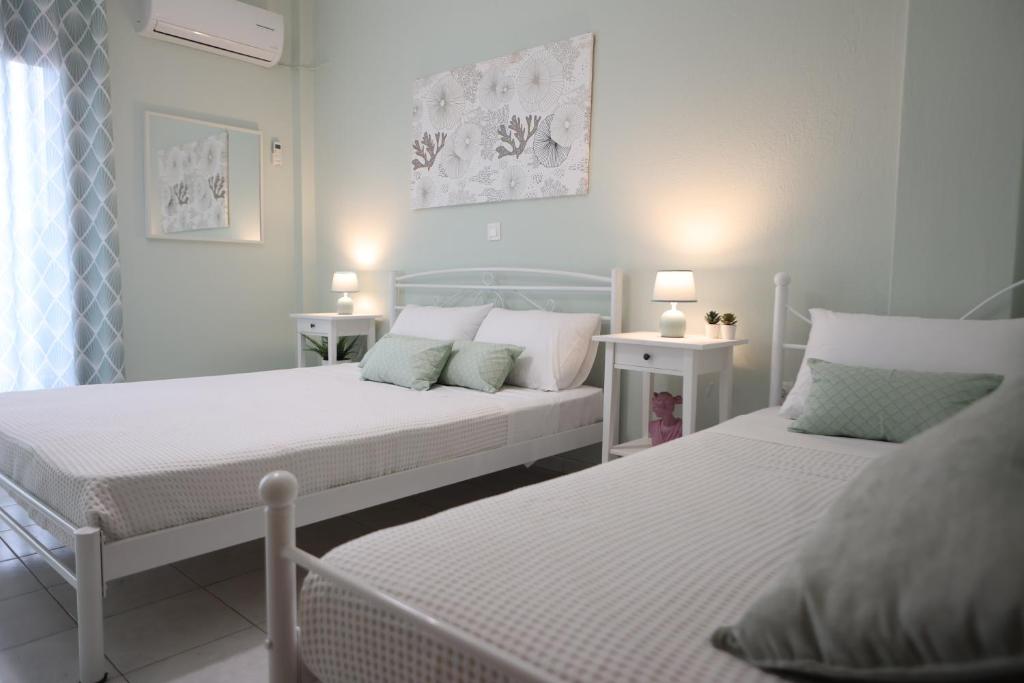 皮加迪基亞的住宿－Island Boutique Apartments，一间卧室设有两张床和两个床头柜
