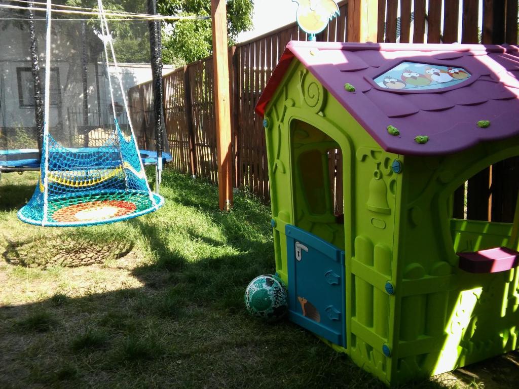 une maison de jeux verte et violette avec un ballon et une balançoire dans l'établissement Pokoje przy lesie, à Stegna