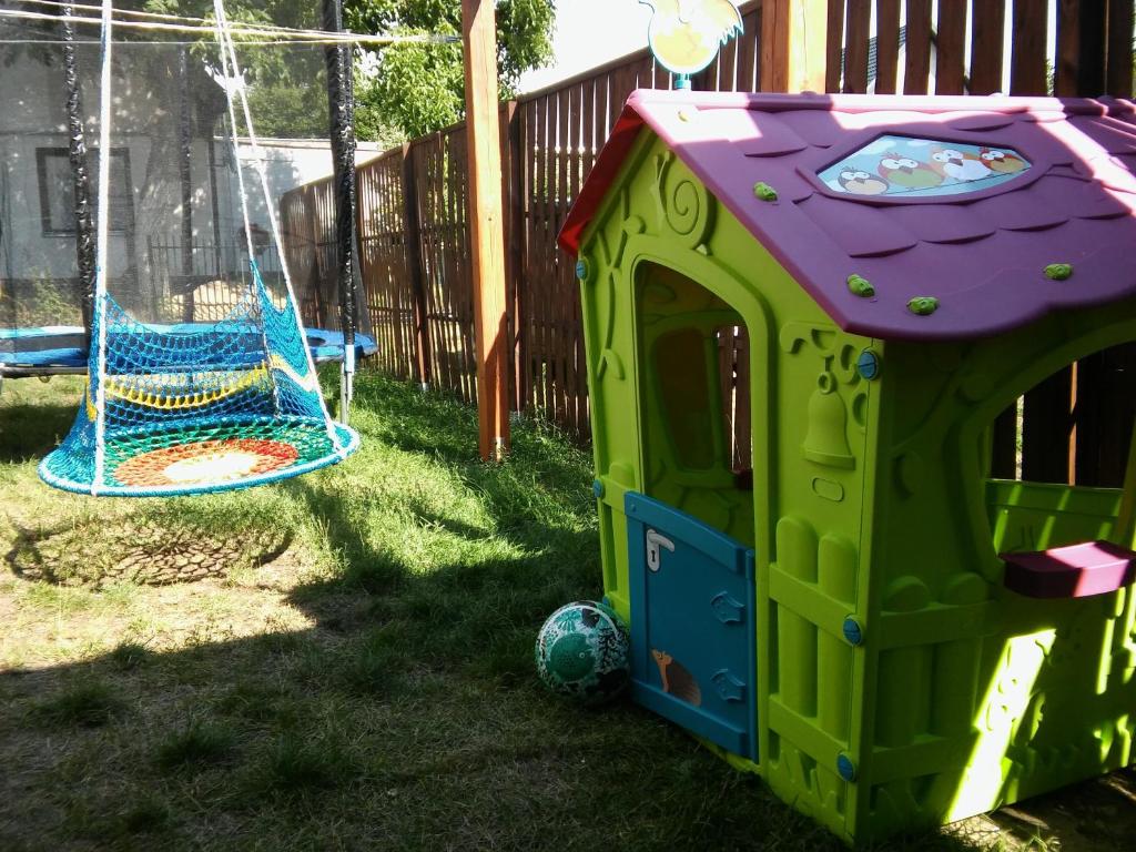 una casetta da gioco verde e viola con una palla e un'altalena di Pokoje przy lesie a Stegna
