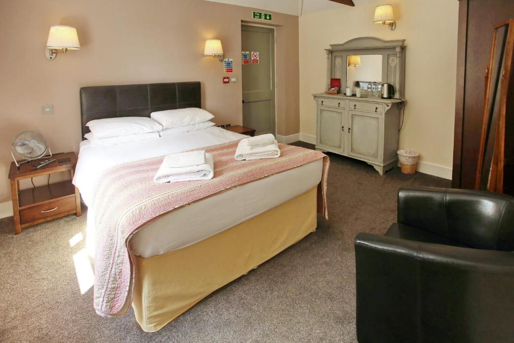 um quarto com uma cama grande com duas toalhas em The Barleycorn em Marlborough