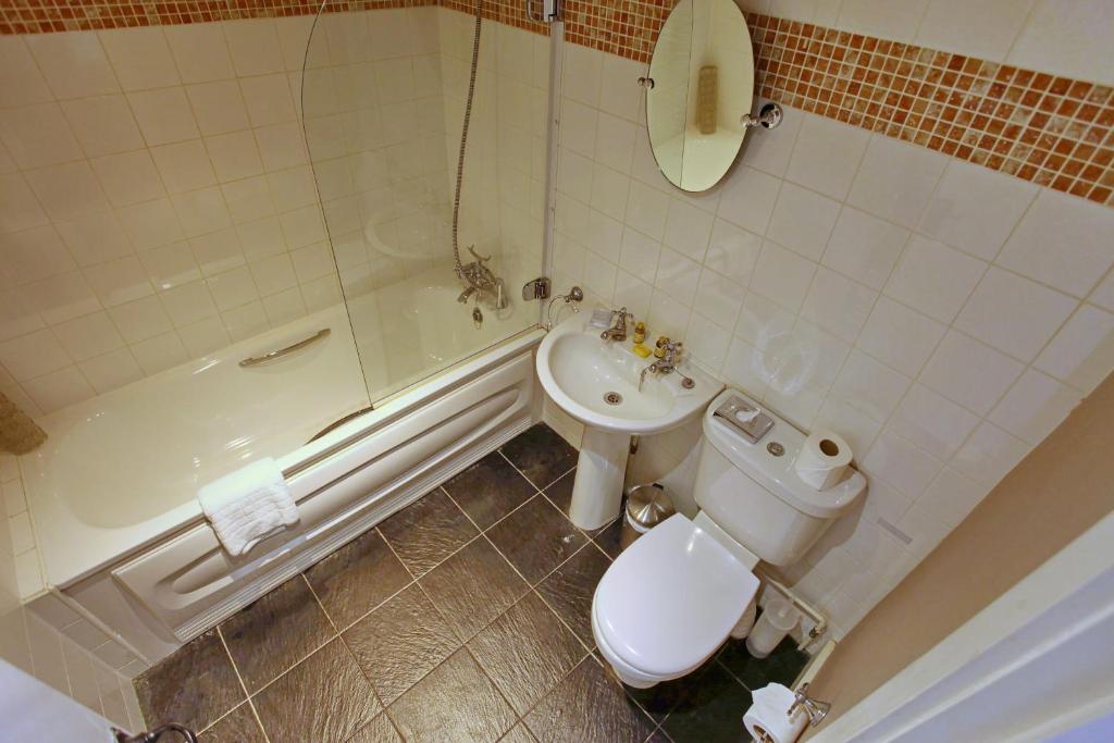 a bathroom with a toilet and a tub and a sink at The Barleycorn in Marlborough