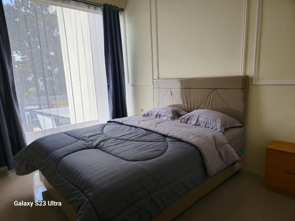 1 cama en un dormitorio con ventana grande en Ni_Er Guesthouse by Mr.Tsabalala, en Panjunan