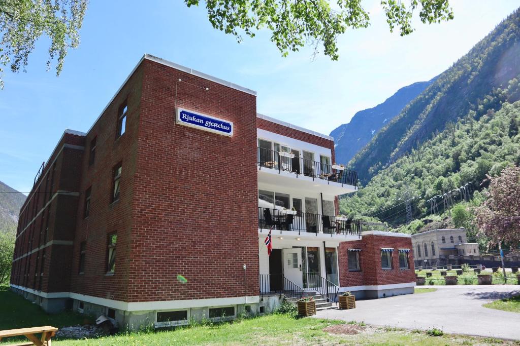 un edificio di mattoni con un cartello sul lato di Rjukan Gjestehus a Rjukan