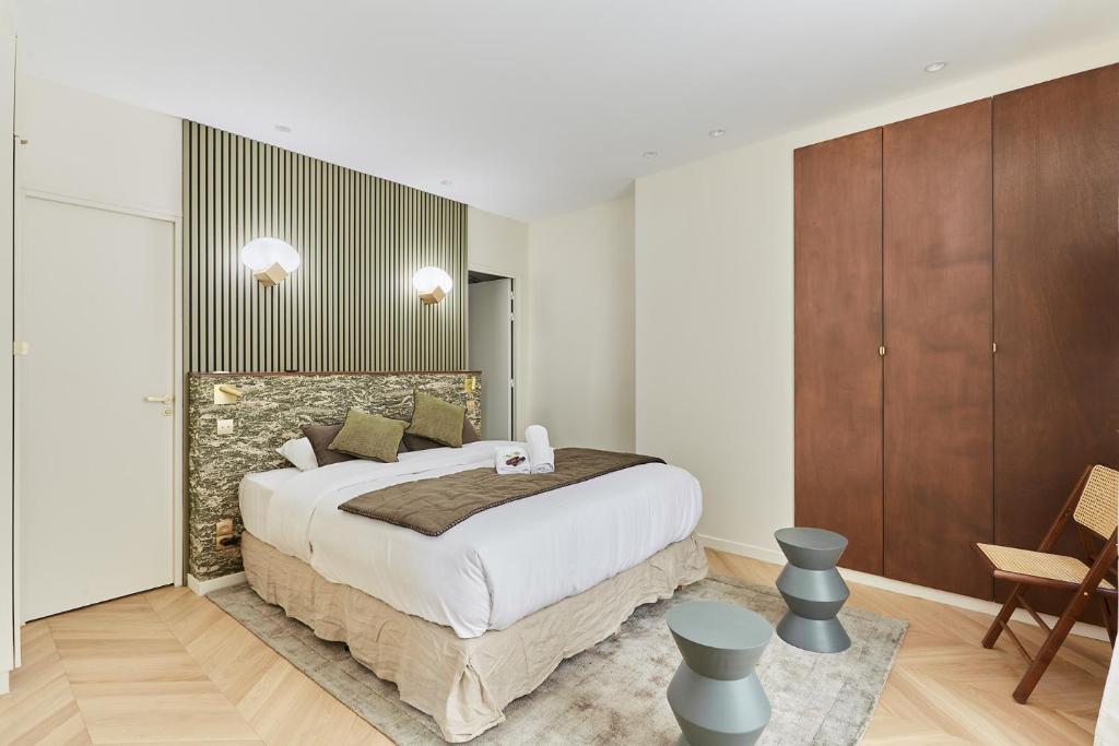 - une chambre avec un grand lit et des placards en bois dans l'établissement Apartment Champs Elysée bu Studio prestige, à Paris