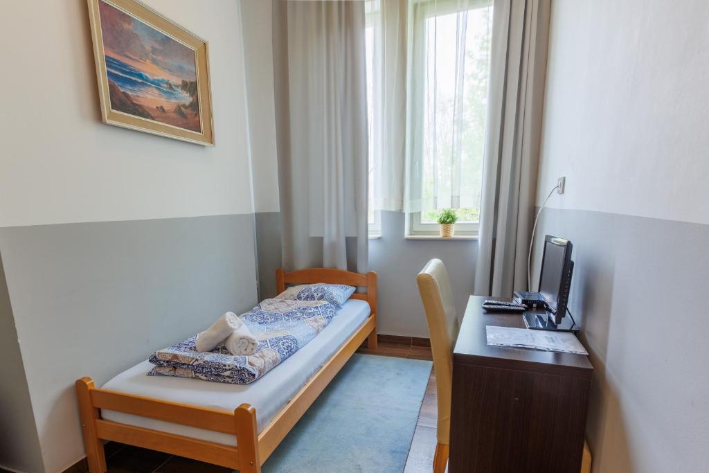 Habitación con escritorio, cama y ordenador. en Motel Kobilj, en Banja Luka