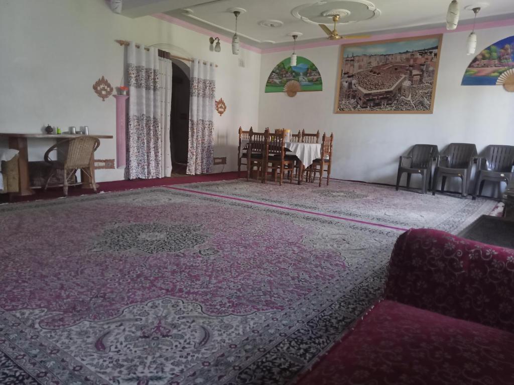a living room with a purple rug and chairs at Grand Inayat in Srinagar