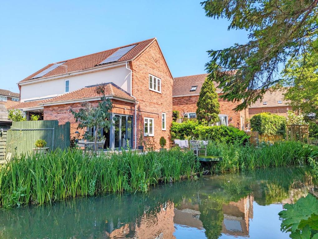 a brick building next to a body of water at Moorhen Lodge in Wickham